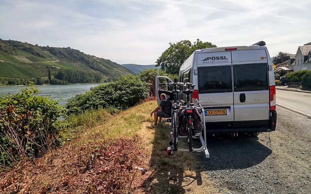 Gekochte buscamper geparkeerd langs een kanaal
